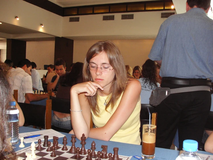 a girl playing a game of chess in a restaurant