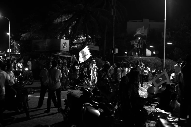 several people in a large crowd near street lamps