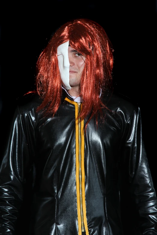 a male in a black leather jacket with orange streaks