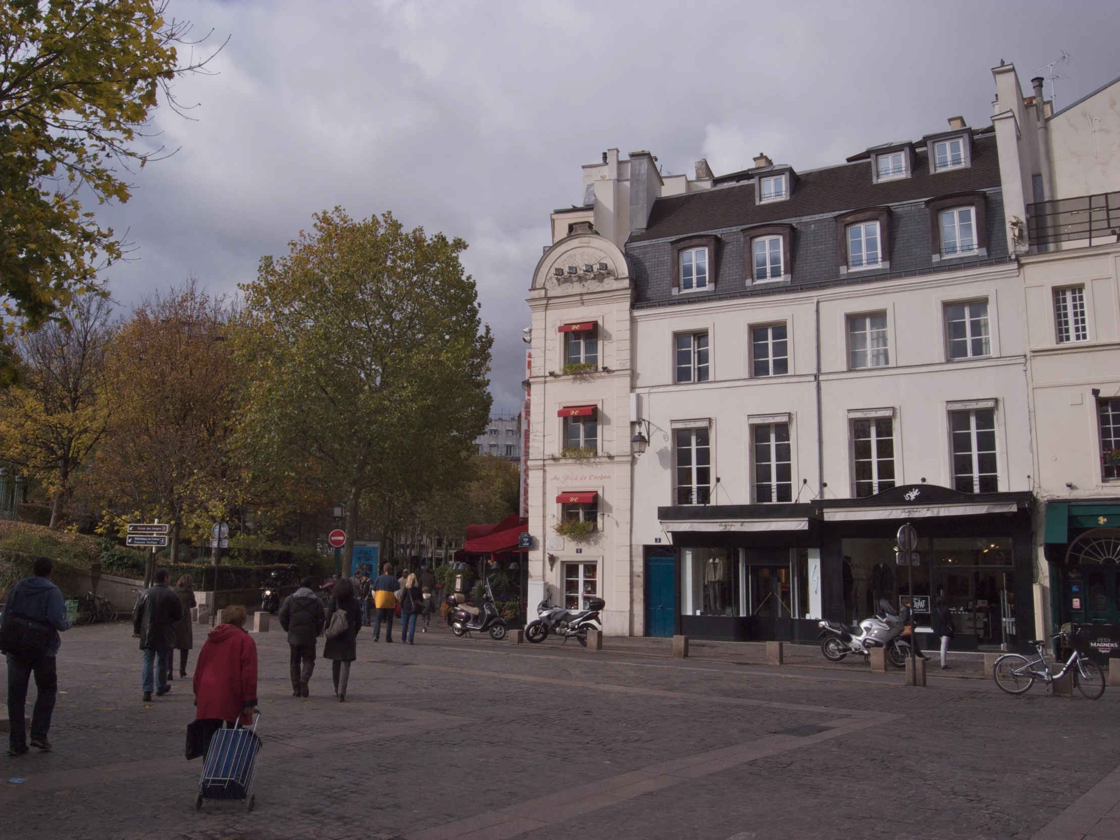 a group of people walking around in front of a white building