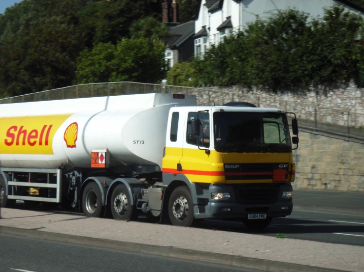 a yellow and white truck traveling down the road