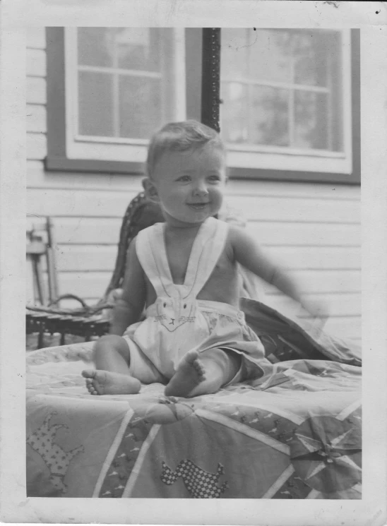 a little girl that is sitting down on her bed