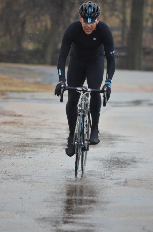 a bicyclist riding in heavy rain in the middle of a rural area