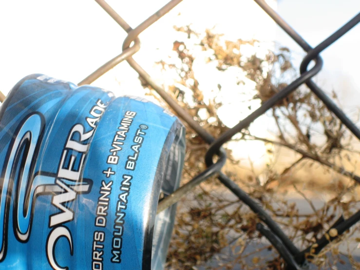 there is an image of a closeup of a bottle on a fence