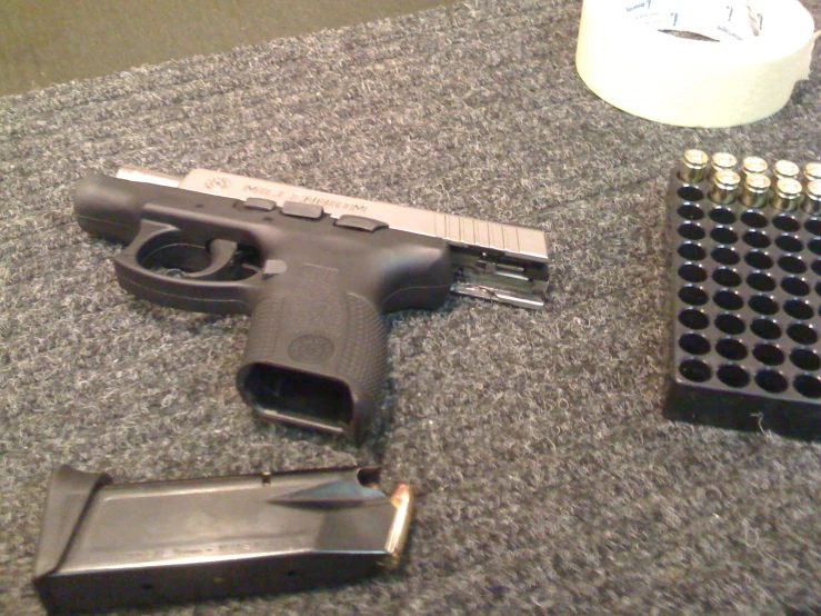 a gun and other items on a carpet