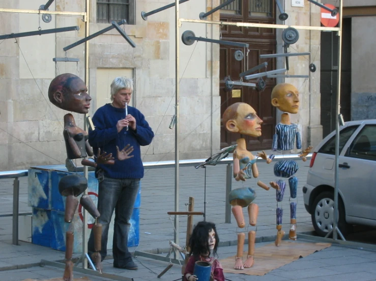 people are standing around a group of sculptures in the city