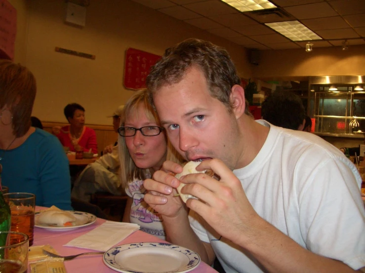 two people eat sandwiches at a fast food restaurant