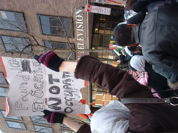 people holding signs and protesting in front of a building