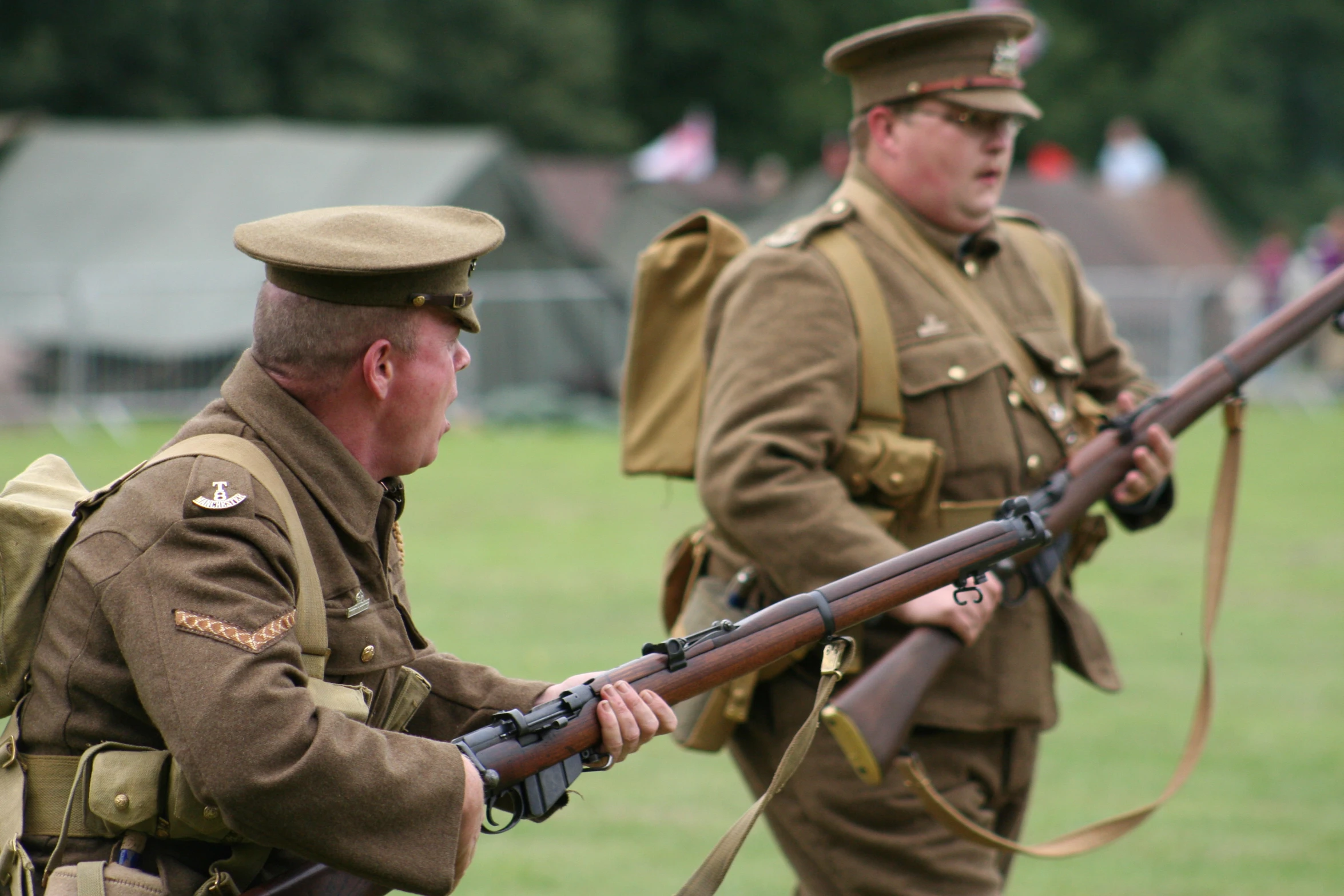 men in uniforms are holding rifles with a large group of other men