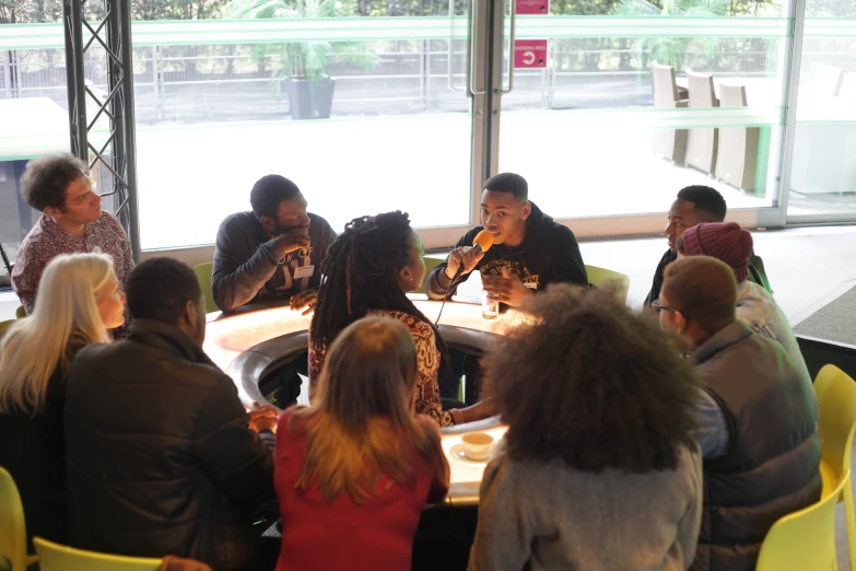 several people are sitting at a table with food