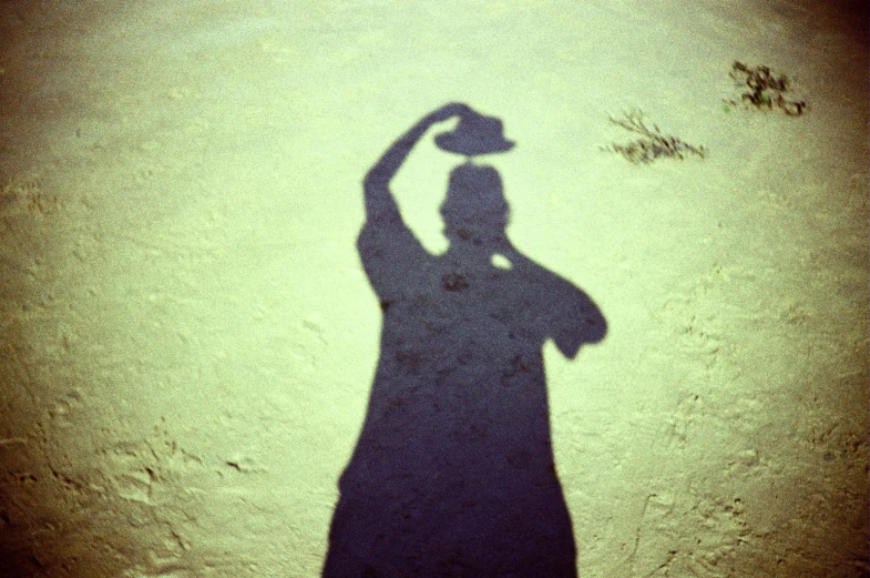 there is a shadow on the wall as a person casts a hat on his cap