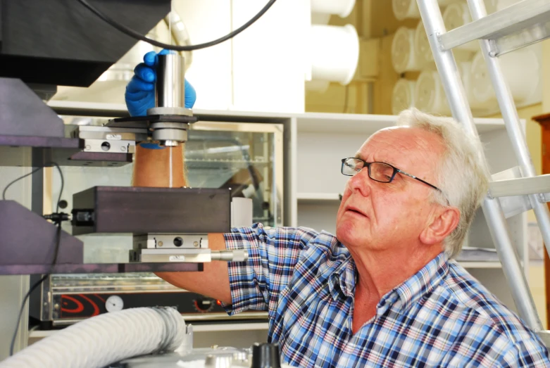 a man standing next to a machine working on it