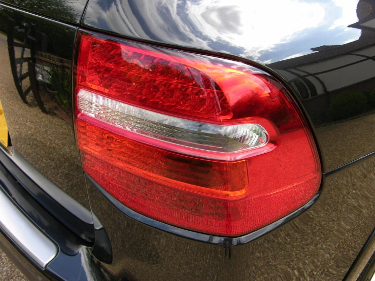 the tail lights of a black car are shown