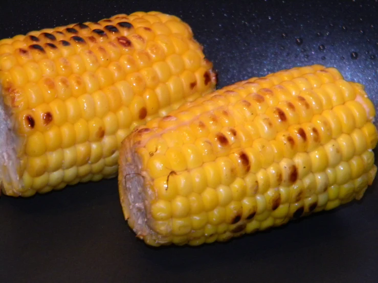 two ears of corn on the cob, sitting in a pan