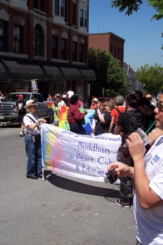 people walking down the street holding a large banner