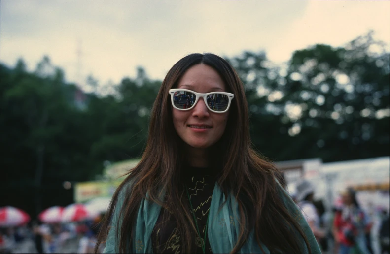 a person wearing sun glasses and some people in the background