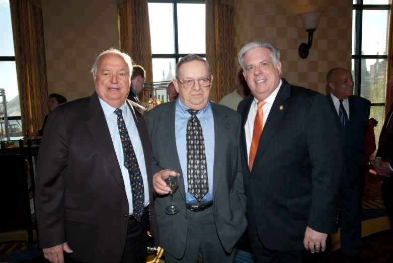 two men in suits are standing with each other and one has a medal