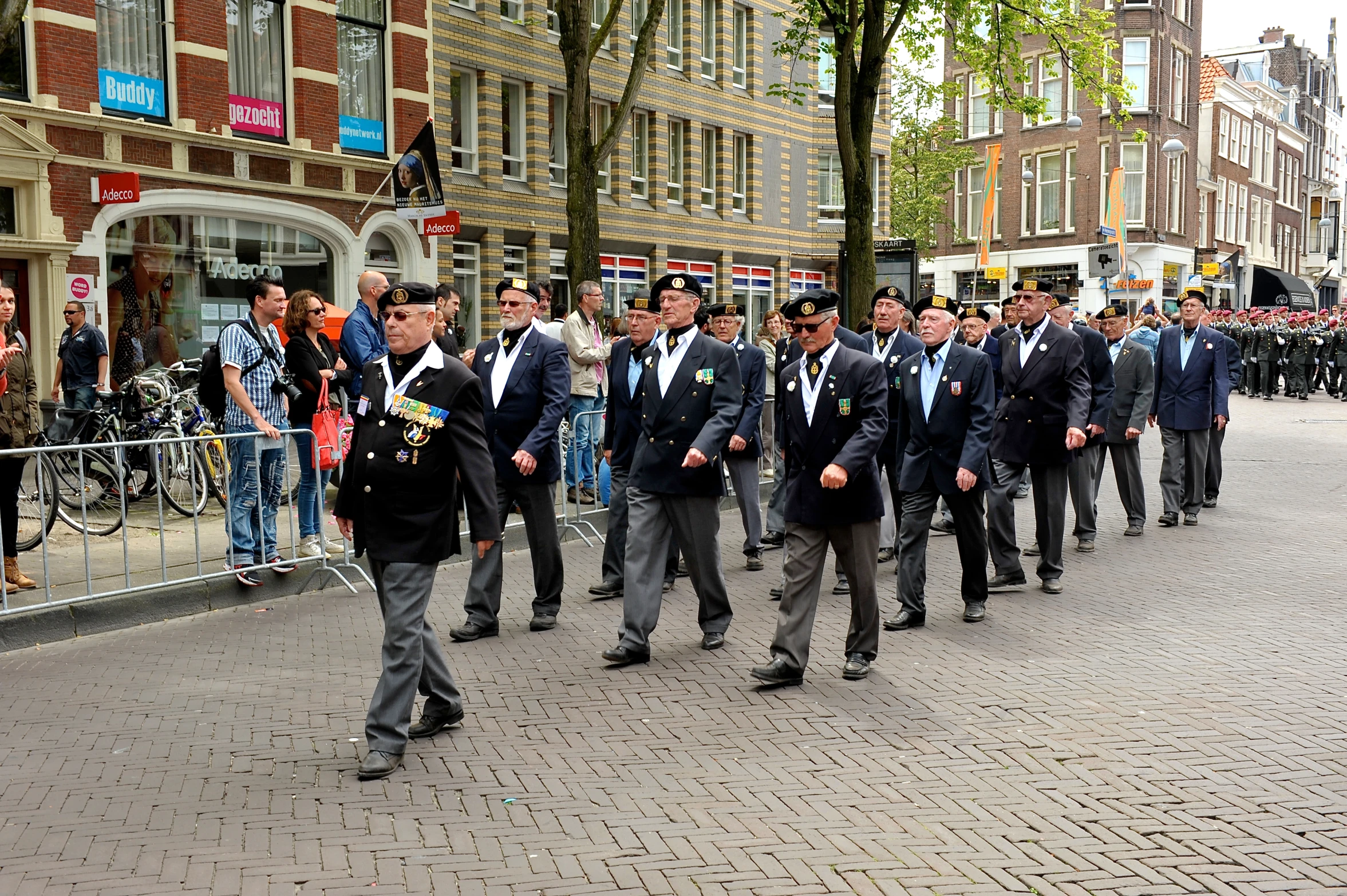 a group of men in formal wear walking down the street