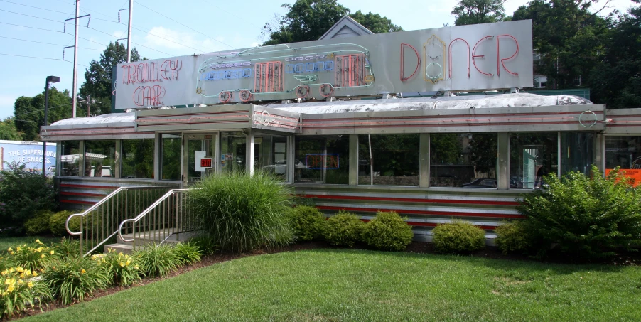 a diner building on a lawn with a lot of windows