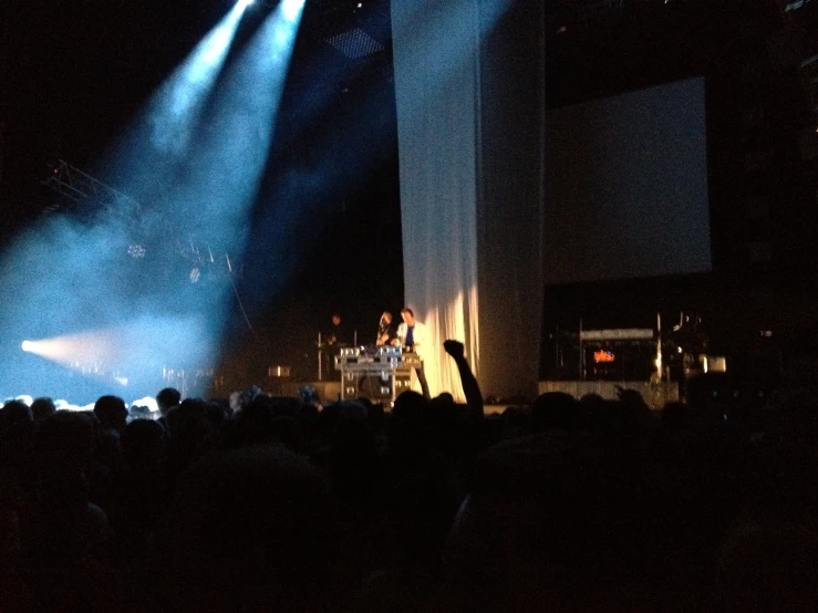 a band performing on stage with blue lights