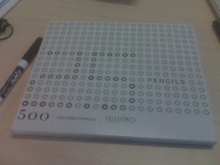 a white notebook next to a pen on top of a table