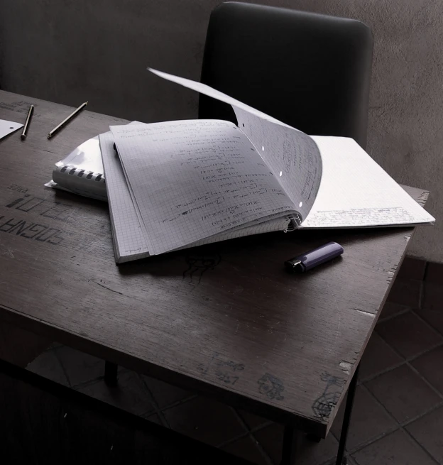 a large open notebook sits on top of an empty table