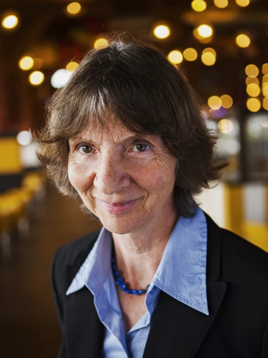 a woman is smiling for a portrait in a bar