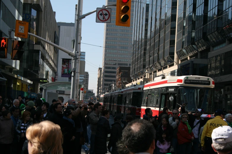 a busy city street filled with people and a white bus