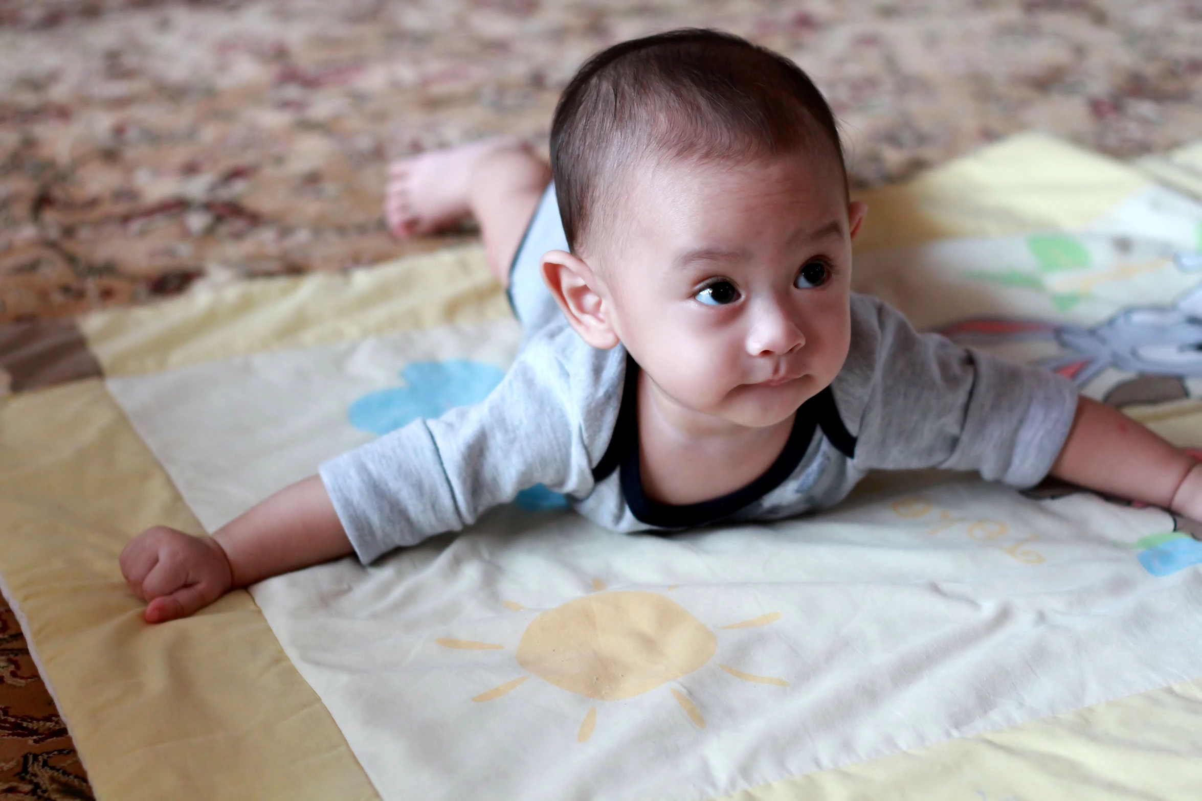 a little baby on the ground with a blanket