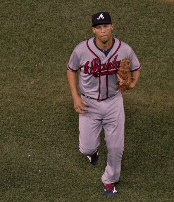 a professional baseball player holding his glove on a field