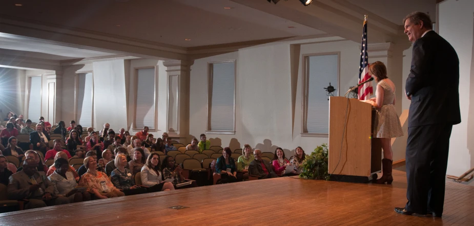 a man standing at a podium in front of an audience