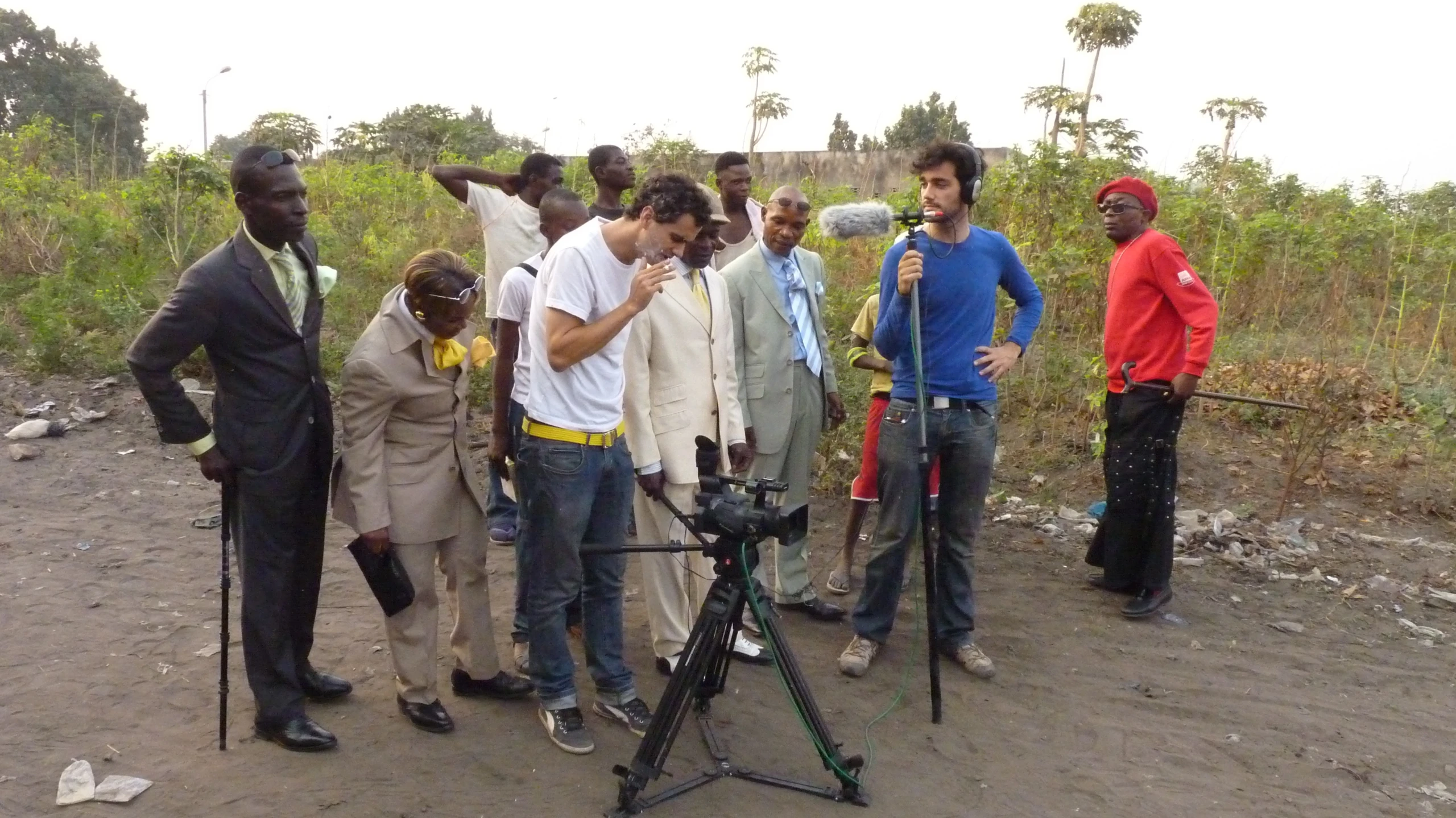 people standing around with tripod and camera in open field