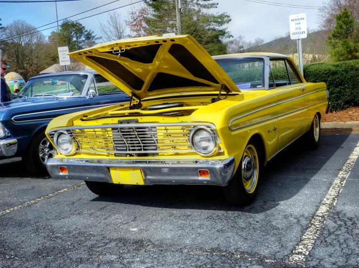 old cars sit parked in a parking lot