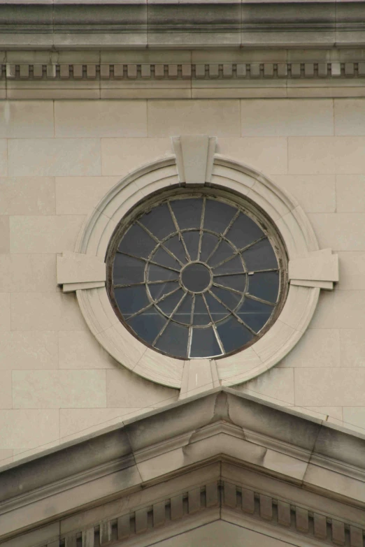 a decorative round window on the side of a large stone building