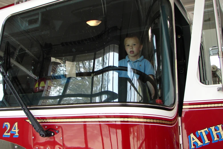 young toddler sitting in a bus looking out the window