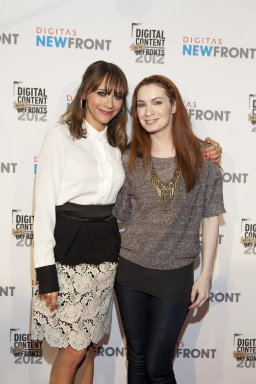 two women standing next to each other on a red carpet