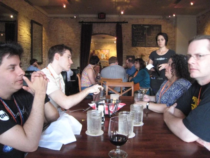 a group of people are at a wooden table eating