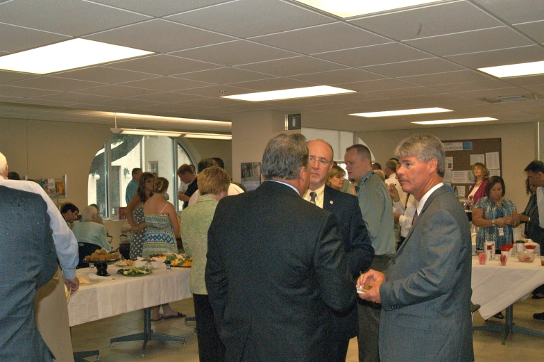 several men are having a conversation in a conference room