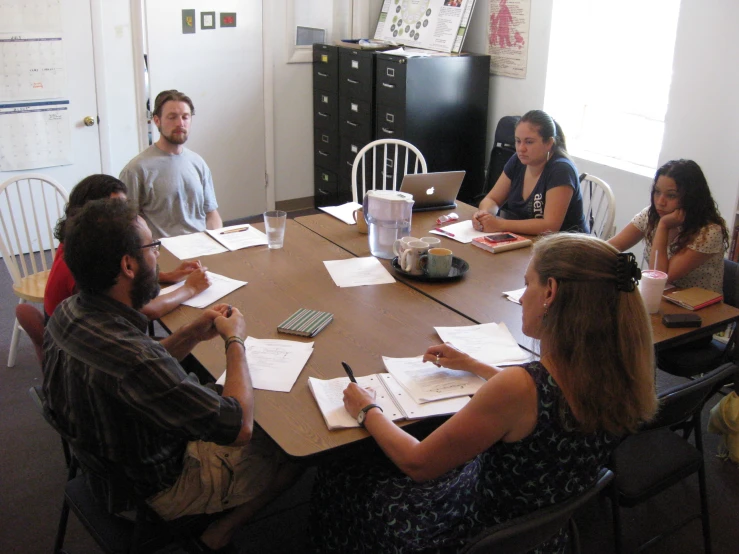 a group of people seated around a round table