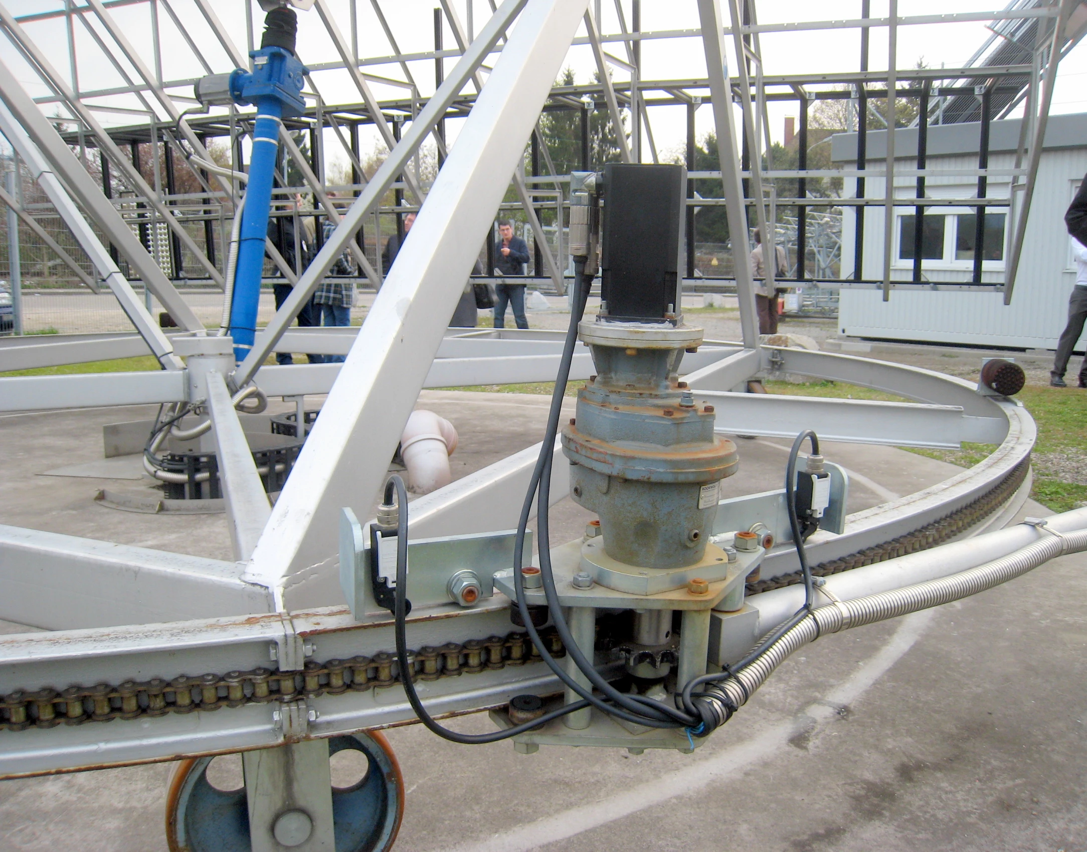 a machine in an industrial area with people standing around it