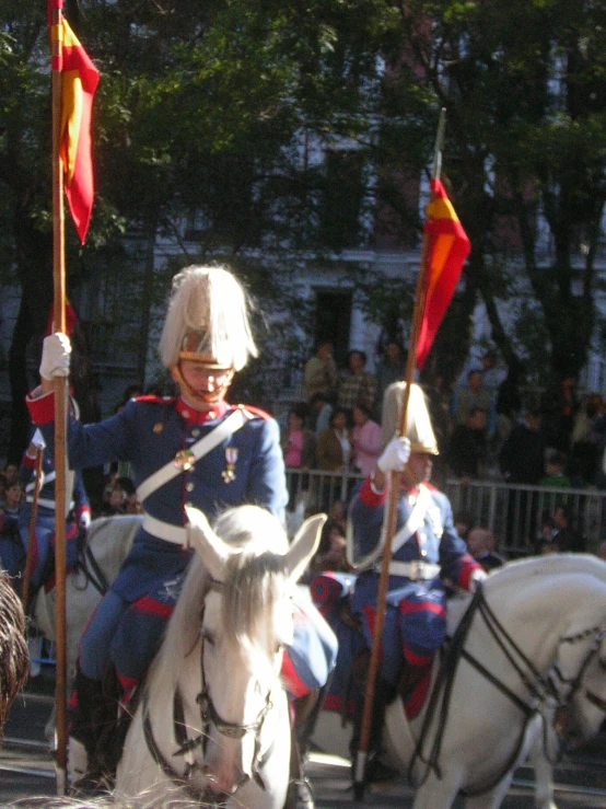 the people are dressed in uniform and riding horses