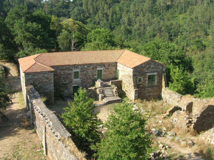 an old stone house surrounded by trees and rocks