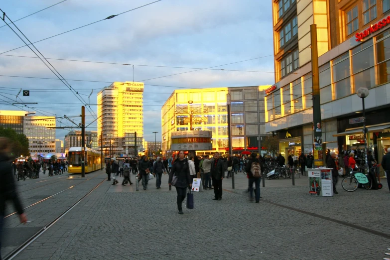 several people walking and walking across an empty square