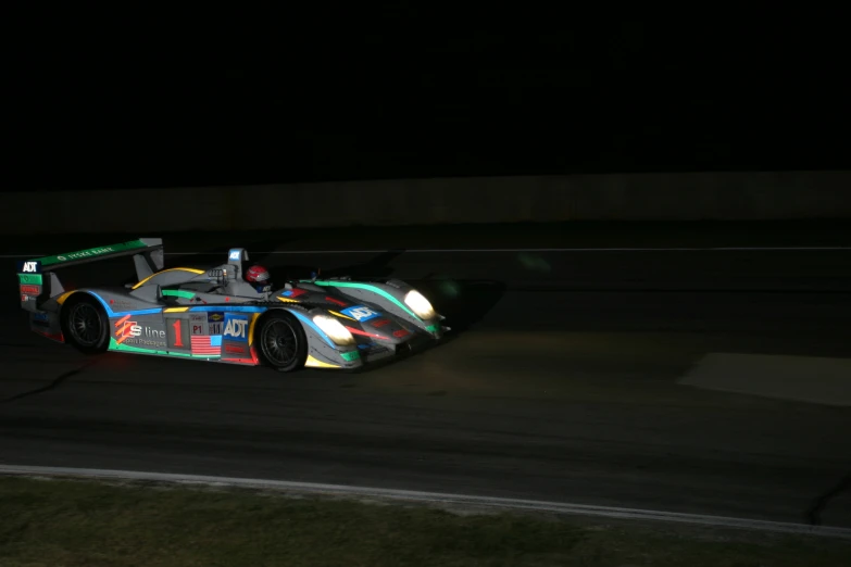 a man driving a car down a street in the dark