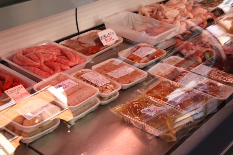 trays filled with different kinds of meat displayed in case