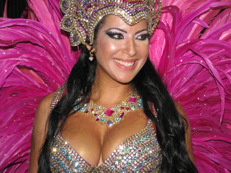 a woman in a carnival costume with large, shiny head piece