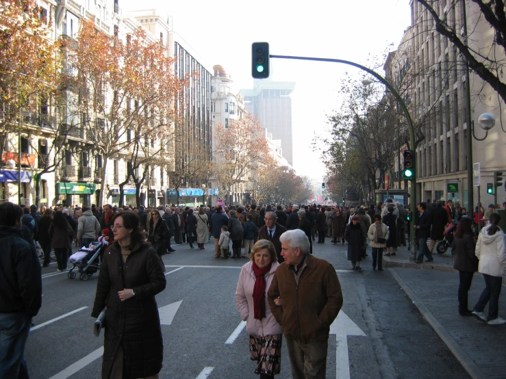 pedestrians crossing a busy city street while traffic is green