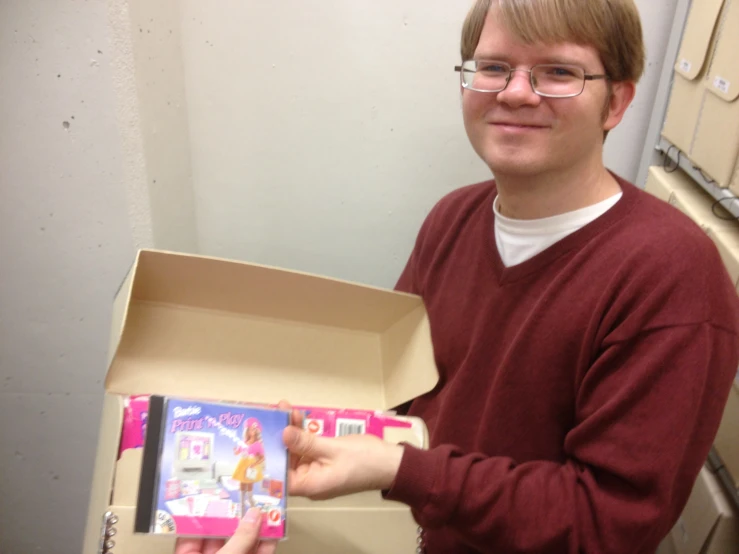 a man is holding a cardboard box with pictures inside it