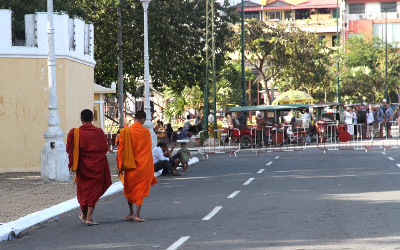 two monks walking down the street carrying umbrellas