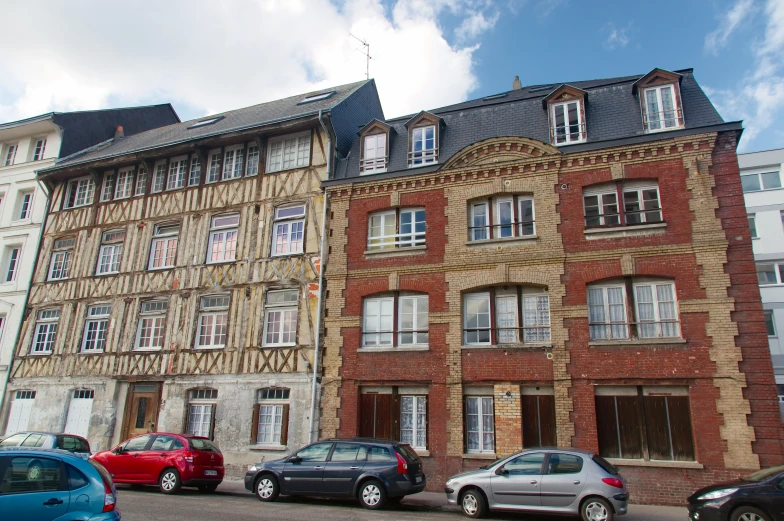 cars parked in front of a row of older apartment buildings